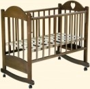 Детская кроватка Таисия-6 c колесами и качалкой, имеет 3 уровня ложа, автостенку и легко трансформируется в диван; цвет орех